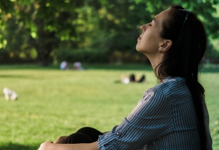 אישה שנמצאת בטבע ולקוחת נשימה עמוקה, דבר שחשוב מאוד לבריאות הכללית של הגוף