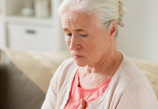 אישה מבוגרת שמחזיקה את החזה ותוהה עם ויטמין D אכן יגביר לה את הסיכוי לחלות במחלות לב