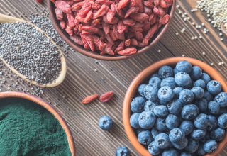 קערות עם מזונות על שונים שעשירים במיוחד בחומרים מזינים שחיוניים לבריאות הגוף נקראים מזונות על אם סופר פודס (Superfoods)