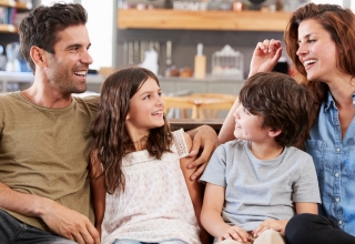 משפחה מאושרת שיושבת על הספה וניהנת יחד