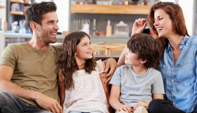 משפחה מאושרת שיושבת על הספה וניהנת יחד