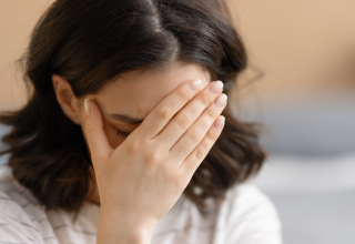 אישה עם רגישות להיסטמין שסובלת מכאב ראש לאחר שאכלה מזונות עשירים בהיסטמין