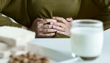 אישה שסובלת מבעיות עיכול כתוצאה מרגישות למזונות שונים